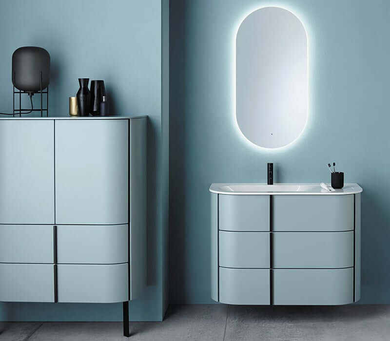 Miroir ovale au dessus d'un meuble de salle de bain