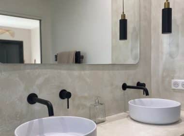Une salle de bain réalisée avec un revêtement béton et des vasques à poser